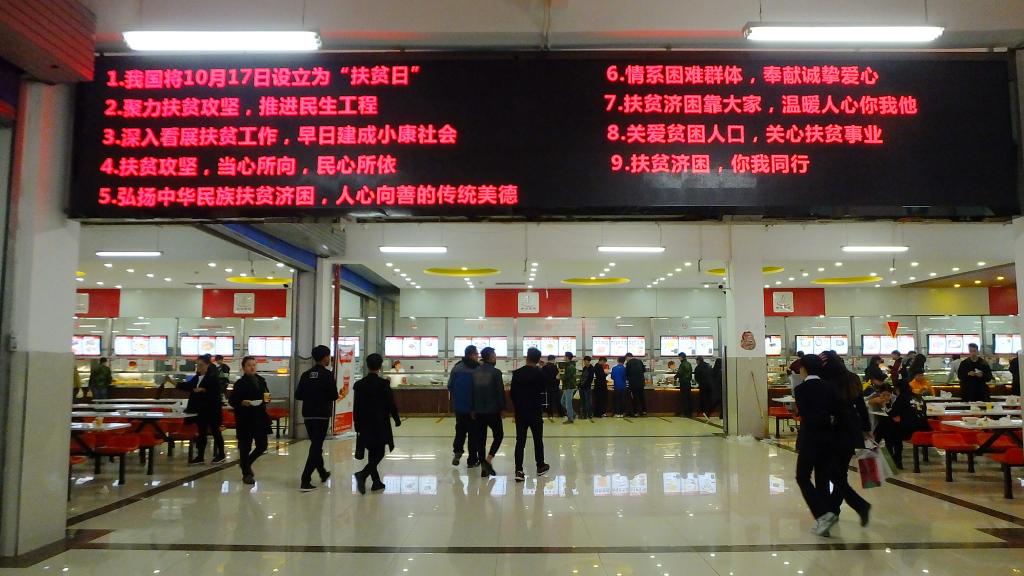 学院食堂液晶显示屏上的扶贫日宣传标语
